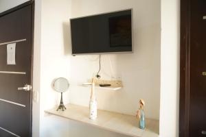 TV en la pared con un estante con espejo en Hotel Sun River, en Barranquilla
