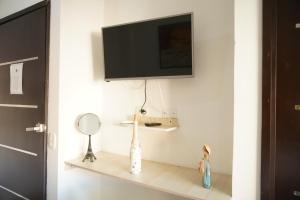 a tv on a wall with a shelf with a mirror at Hotel Sun River in Barranquilla