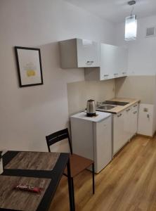 a kitchen with white cabinets and a table and a stove at Warsaw strict center, WiFi, AC, next to central railway station, Złote Tarasy, PKiN, Warszawa ścisłe centrum in Warsaw +5 photos