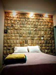 een stenen muur achter een bed in een slaapkamer bij Casa Scalesia in Puerto Baquerizo Moreno