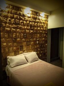a bedroom with a stone wall with a bed at Casa Scalesia in Puerto Baquerizo Moreno
