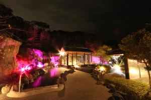 um resort iluminado à noite com luzes roxas em リバティーリゾート久能山 