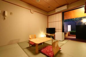 a room with a table and chairs and a television at リバティーリゾート久能山 