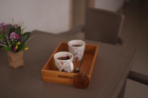 a wooden box with two cups and a vase of flowers at Hotel Sun River in Barranquilla
