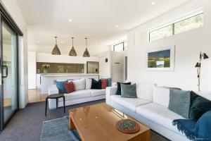 uma sala de estar com um sofá branco e uma mesa em Okataina - Means Place of Laughter, Luxury Retreat em Queenstown