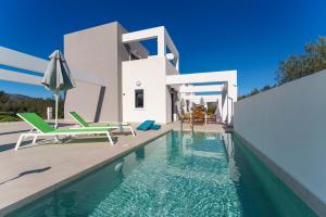 a villa with a swimming pool and a house at Domus Oliva Villas in Haraki