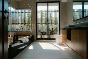 baño con bañera, aseo y ventanas en 台南安平包棟民宿 - 定言豪宅館 en Anping