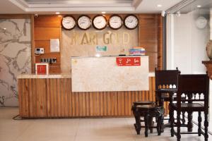 a restaurant with a counter with clocks on the wall at Marigold Hotel & Apartment in Danang