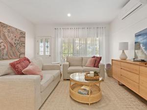 a living room with a couch and a table at Husky Beach House by Experience Jervis Bay in Huskisson