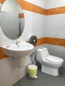 a bathroom with a sink and a toilet and a mirror at Pim Bungalow in Mae Haad