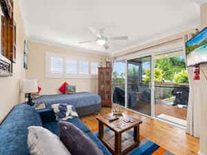 un salon avec un canapé et une table dans l'établissement Jacaranda Cottage 5A Nelson Street, à Nelson Bay