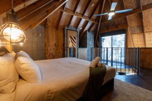 Un dormitorio con una cama grande en una habitación con techos de madera. en Grampians Getaway, en Halls Gap