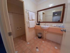 y baño con lavabo y espejo. en Criterion Hotel-Motel Rockhampton en Rockhampton