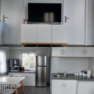 a kitchen with white cabinets and a stainless steel refrigerator at Self Contained 2BR holiday unit in Richmond Tasman in Richmond