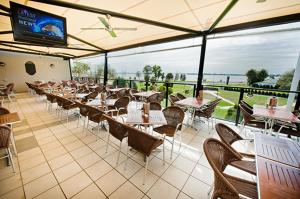 a restaurant with tables and chairs and a television at Club Mulwala Resort in Mulwala