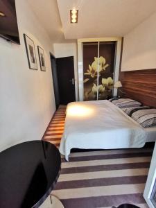 a bedroom with a white bed and a table at Apartament prywatny salon z aneksem kuchennym i sypialnią w hotelu Diva in Kołobrzeg