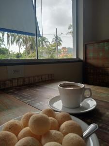 a plate of donuts and a cup of coffee on a table at Pousada Morada dos ANJOS in Penha