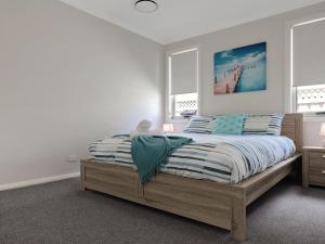 a bedroom with a bed and two windows at Pollys in Callala Bay