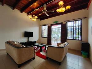 a living room with two couches and a tv at Jawa Townstay in Melaka