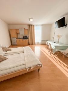 ein Schlafzimmer mit einem Bett und einem Tisch sowie eine Küche in der Unterkunft Frühstückspension Ingrid in Neutal