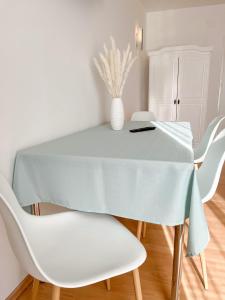 a white dining room table with white chairs at Frühstückspension Ingrid in Neutal