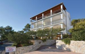 - un bâtiment blanc avec un balcon au-dessus d'un mur en pierre dans l'établissement Apartments Nadi - sea view, à Hvar