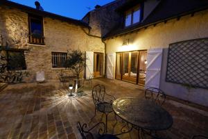 un patio al aire libre con mesa y sillas por la noche en LUXURY Bergerie Corsica, PARIS Orly et disney, en Varennes-Jarcy