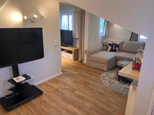 sala de estar con sofá y TV de pantalla plana en Ferienwohnung Giacomelli 2, en Rottach-Egern