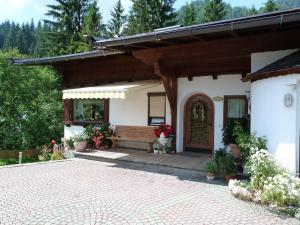 eine Veranda eines Hauses mit einer Bank und einer Tür in der Unterkunft Haus Brantner in Waidring