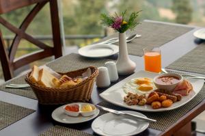 a table with a breakfast of eggs and bread at Himalaya Drishya Resort in Dhulikhel