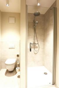 ein Bad mit einer Dusche, einem WC und einem Waschbecken in der Unterkunft Apartments in the MAREMÜRITZ Yachthafen Resort, Waren an der Müritz in Waren (Müritz)