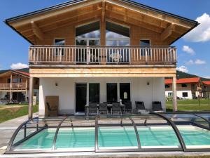a house with a deck and a swimming pool at Chalet Alpenblick, Inzell in Inzell