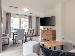 a living room with a tv and a table and chairs at Chalet Arber in St Englmar with its own HotTube in Sankt Englmar