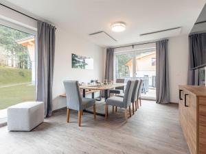comedor con mesa y sillas y ventana grande en Chalet Arber in St Englmar with its own HotTube, en Sankt Englmar