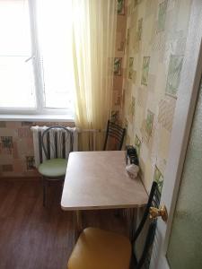 ヴォルシスキーにあるApartment on Druzhbyの窓のある部屋(テーブル、椅子付)