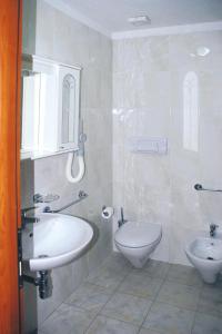 bagno con lavandino e servizi igienici di Terraced house in holiday residence Il Nido dei Gabbiani, Porto Pollo a Porto Pollo