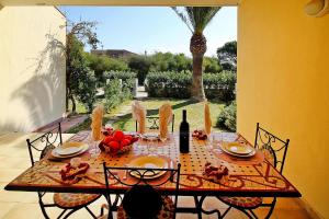 tavolo da pranzo con cibo e bottiglia di vino di Apartment in Costa Rei a Costa Rei