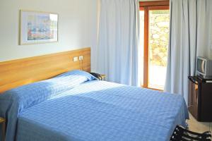 a bedroom with a blue bed and a television at Apartment in Palau near Surf Paradise in Porto Pollo