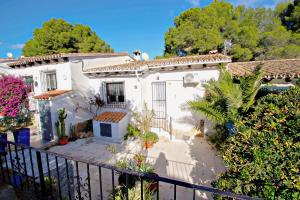 a white house with a fence and trees at Moraira Park - charming cottage in Moraira in Teulada