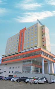 a hotel with cars parked in front of it at HARRIS Hotel Samarinda in Samarinda
