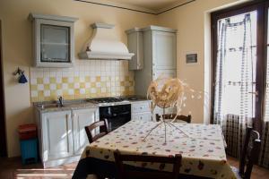 Room in Farmhouse - Apartment in Farmhouse Casolare dei Fiori في Chiesina Uzzanese: مطبخ مع طاولة وموقد فرن علوي