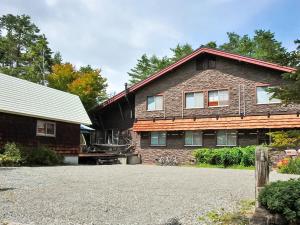 a house with a gravel driveway in front of it at Kunugi Relaxation with 4 modern rooms in Hakuba