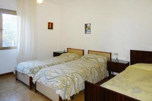 een slaapkamer met 2 bedden en een raam bij Holiday home, Solanas in Solanas
