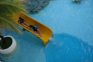 two people riding on a paddle board in a pool at Landcons Hotel & Resort in Pantai Cenang +59 photos