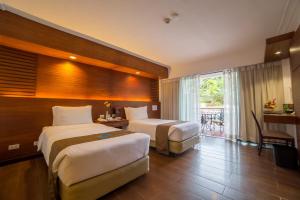 a hotel room with two beds and a balcony at Waterfront Airport Hotel and Casino in Mactan