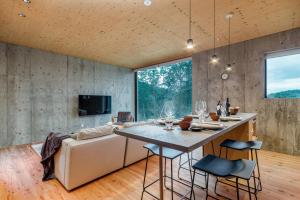 a kitchen and living room with a table and a couch at Puffin by H2 Life in Niseko