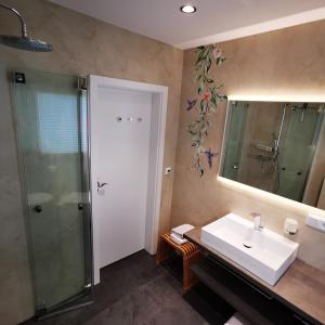 a bathroom with a sink and a shower and a mirror at BB19 Eifel-Ferienhaus am Moseltal mit Saunahaus in Beuren +44 photos