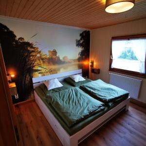 a bedroom with a bed with a painting on the wall at BB19 Eifel-Ferienhaus am Moseltal mit Saunahaus in Beuren