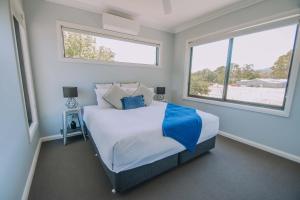 a bedroom with a large bed and two windows at Lusso KV in Whitfield