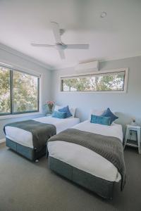 two beds in a room with two windows at Lusso KV in Whitfield